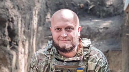 Тарас Давидюк сидить у військовій формі у бронежилеті в окопі