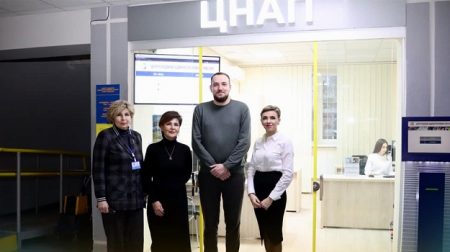 Четверо людей стоять перед входом у ЦНАП у Районі Ювілейний у Рівному