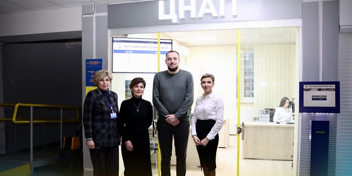 Четверо людей стоять перед входом у ЦНАП у Районі Ювілейний у Рівному